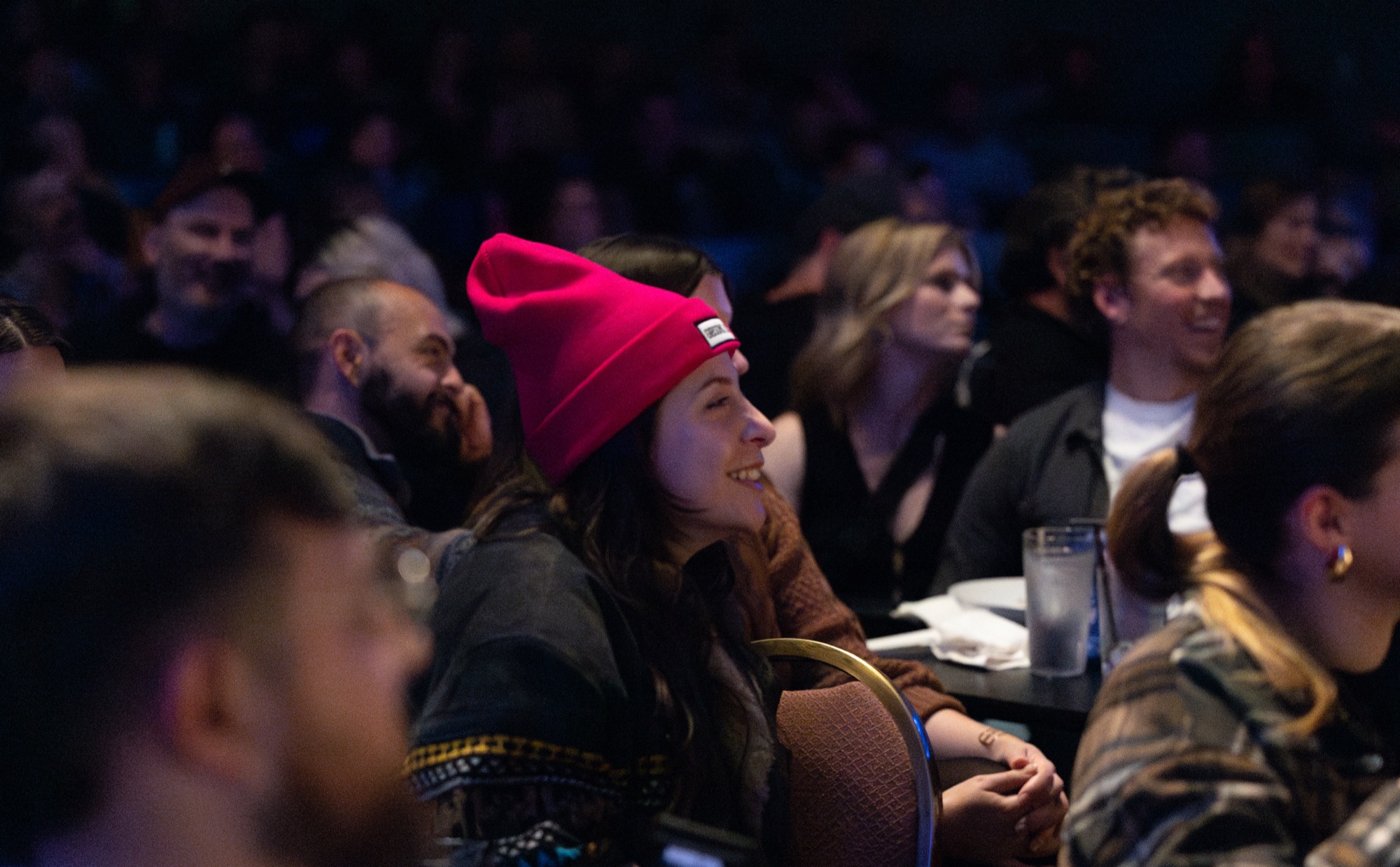 A table of guests laughing together over drinks during a show at House of Comedy Vancouver